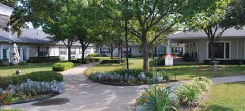 Exterior courtyard of a Brookdale Lake Highlands senior living campus with trees and walkways.