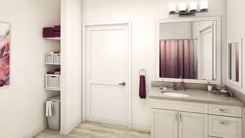 A clean and modern bathroom featuring a white door, a vanity with a sink and countertop, a large mirror above the sink, a purple hand towel hanging on a ring, and a purple shower curtain visible in the reflection. There are shelves with neatly folded towels and storage baskets on the left side, light-colored walls, and wood-style flooring.
