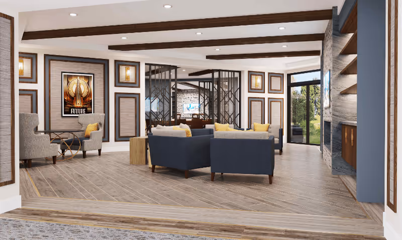 A modern living room area with wooden flooring and ceiling beams. The room features several blue and gray armchairs with yellow cushions arranged around small wooden tables. The walls are decorated with framed art and sconces, and there is a large glass door leading outside. A stone fireplace with built-in shelves is visible on the right side.