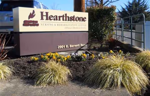 Hearthstone Nursing & Rehabilitation Center sign beside landscaped front yard.