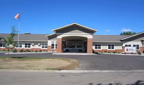 Birch Haven entrance with car under porte-cochère, flagpole, and landscaped front.