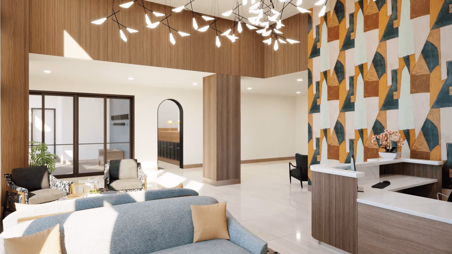 Modern senior living lobby with a seating area, reception desk, geometric accent wall, and contemporary hanging lights.