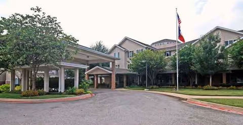 Front view of Whiterock Court senior living facility with covered entrance and flagpole.