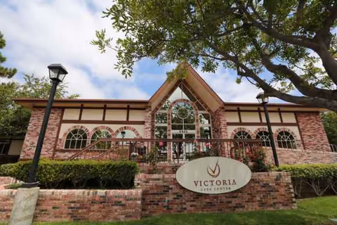 Brick building with arched windows and a prominent Victoria sign at the front.