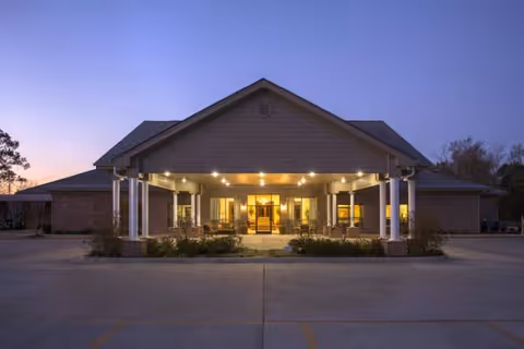 Front entrance of Lake Hamilton Health and Rehab with illuminated walkway at dusk.