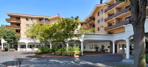 Brookdale Redwood City exterior view with curved porte-cochere and landscaped driveway.
