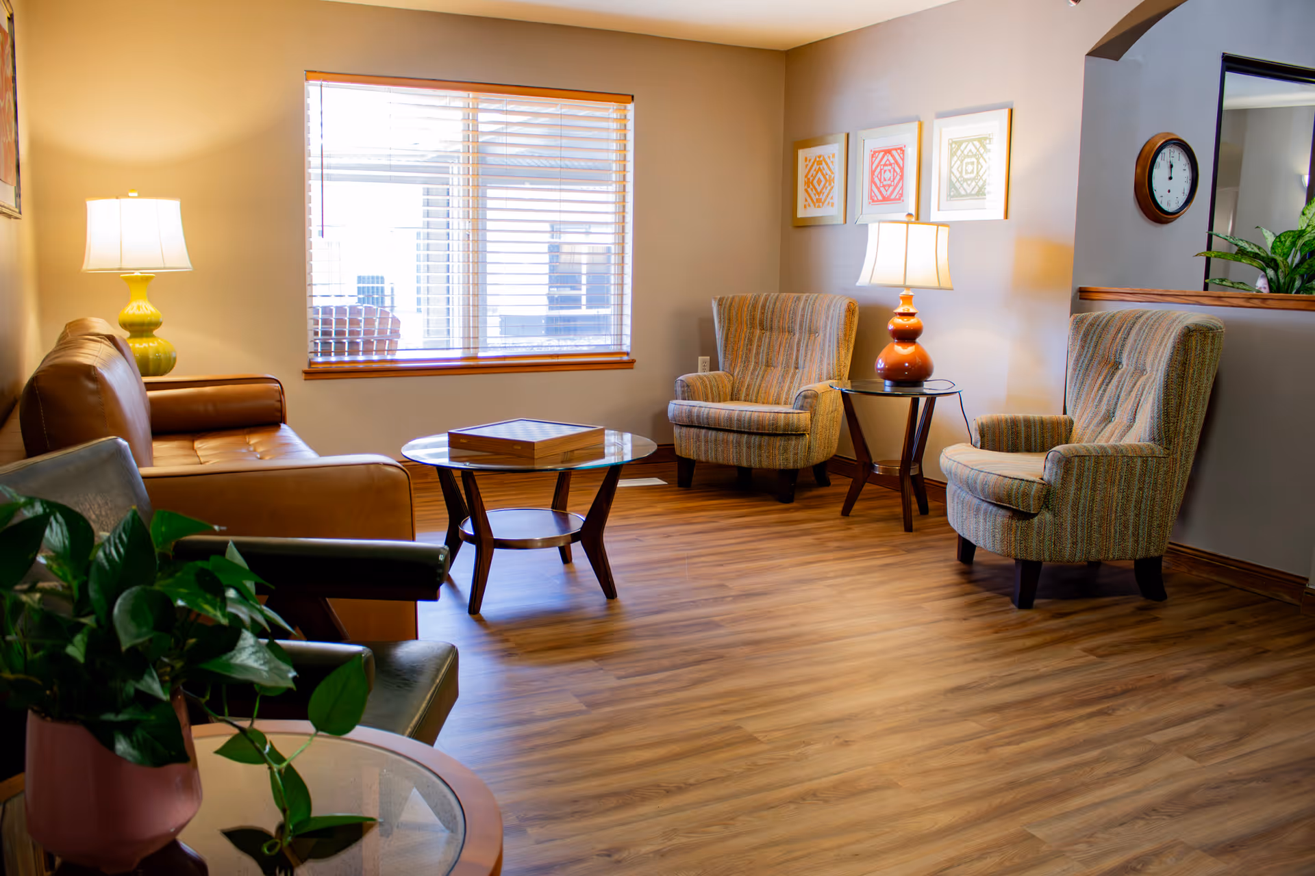 A cozy living area in a senior living facility with two armchairs, a sofa, and a coffee table.