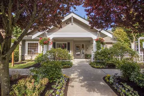 Front view of a Rosewood Courte entrance with hanging baskets and lush landscaping.