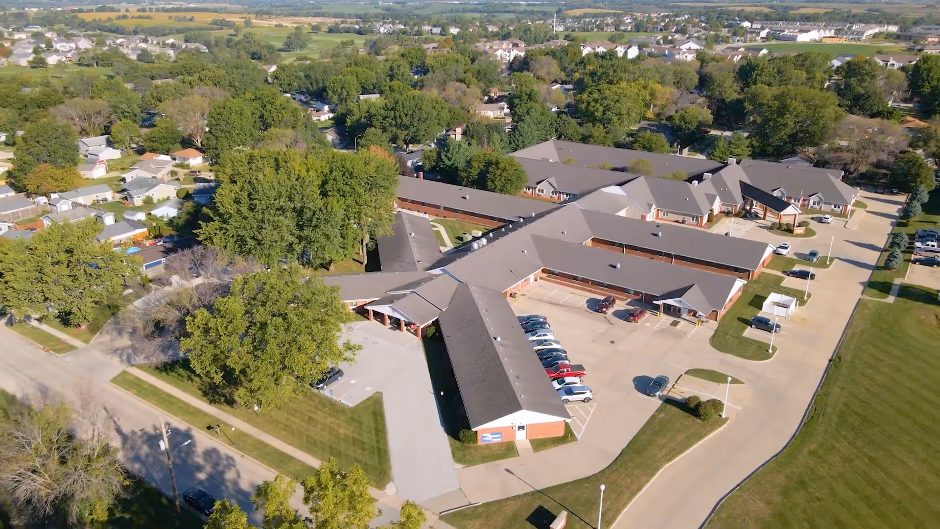 Aerial view of Regency Assisted Living showing the building's exterior, parking area, and surrounding greenery.
