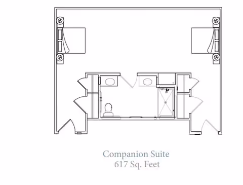 Architectural floor plan of a companion suite measuring 617 square feet, showing two separate sleeping areas each with a bed, two bathrooms with toilets and sinks, and a shared shower area in the center.