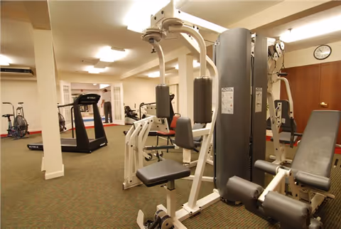 Well-lit interior gym with weight machines, a treadmill, and exercise bikes.