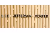 Exterior wall with vertical wooden slats and '830 Jefferson Center' signage.