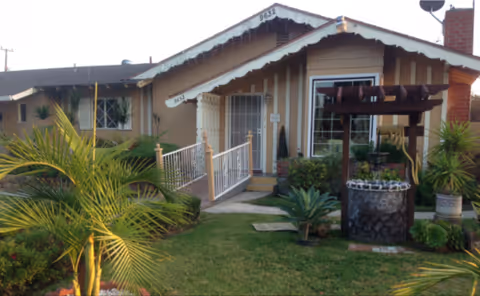 Ameriheart Care Home 2 front entrance, walkway, railing, and well-maintained tropical landscaping.