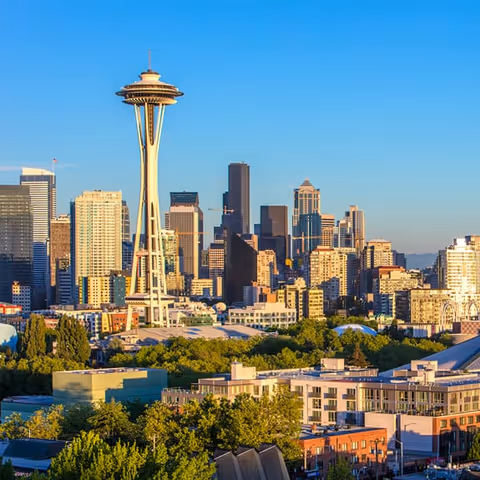 City skyline featuring the Space Needle and various high-rise buildings under a clear blue sky during daylight.