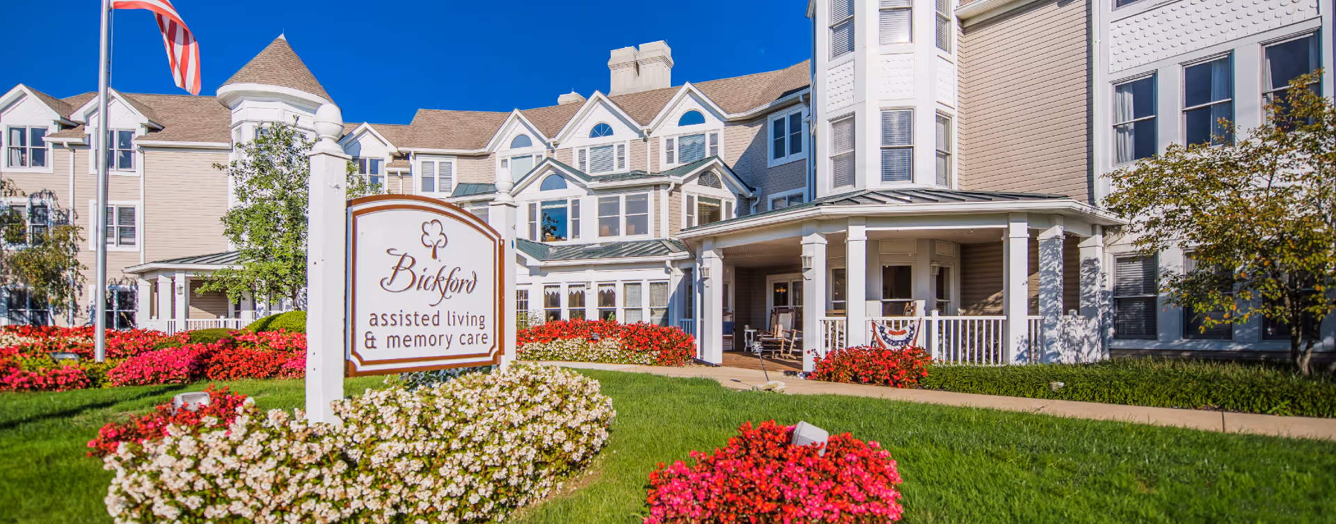 Exterior view of Bickford assisted living facility with front porch and flower beds.