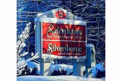 A red and white sign for Salemhaven Rehab & Nursing Center and Silverthorne Adult Day Center, set outdoors with snow on the ground and trees in the background.