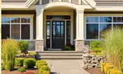 Front entrance of a senior living facility with steps, glass doors, and landscaped surroundings.
