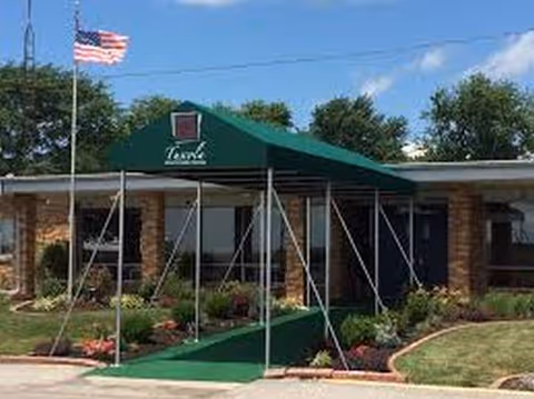 Exterior view of Haven of Tuscola facility entrance with green canopy and flag.