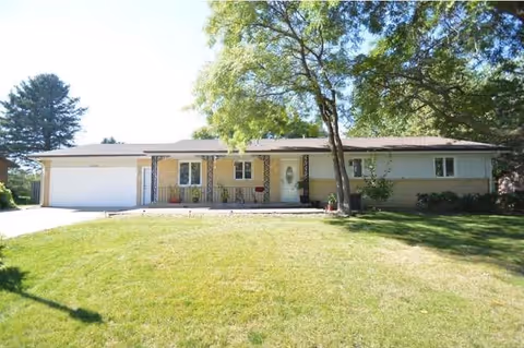Beige, single-story senior facility with a two-car garage and front lawn.