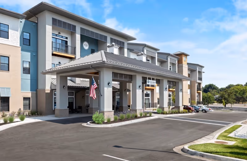 Exterior view of Novel Place Senior Living in Overland Park, showing entrance and surrounding parking.