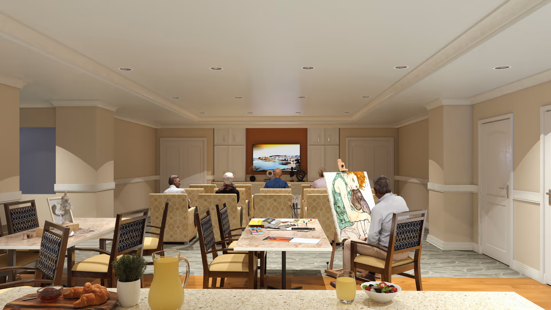 A common room in a senior living facility with several seniors seated facing a television mounted on the far wall. In the foreground, a man is painting on an easel, and tables with chairs are arranged around the room. On one table, there is a pitcher of juice, a glass of juice, a bowl of fruit, and some pastries.
