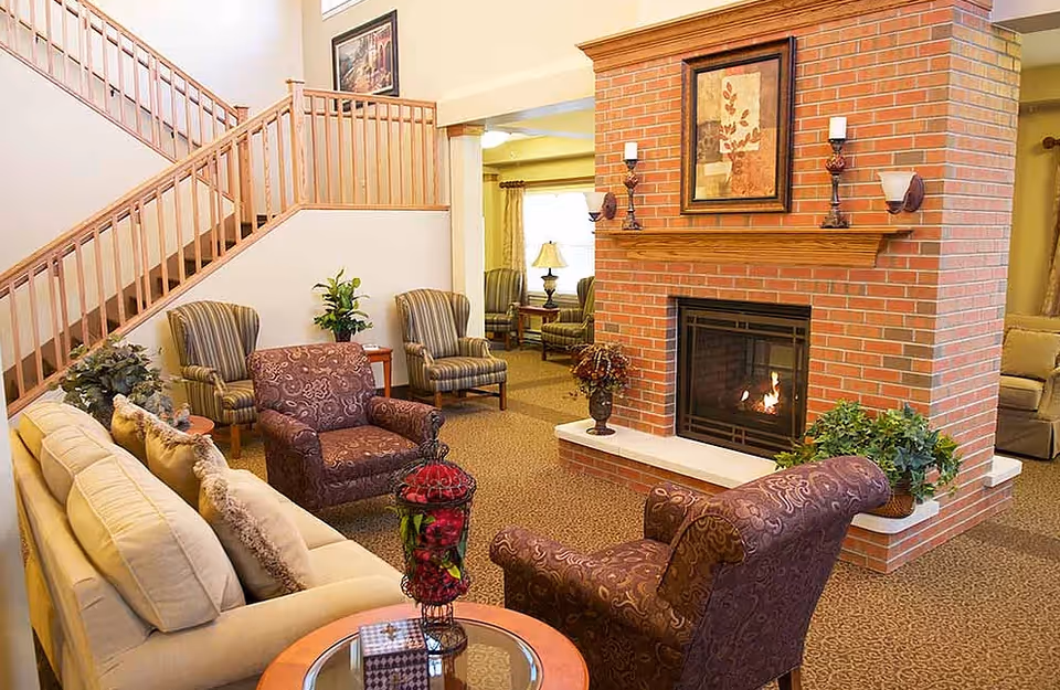 Cozy living room lounge with a brick fireplace, sofas, and armchairs.