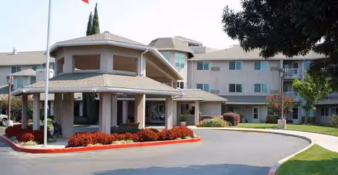 Exterior view of The Hampshire senior living community with a circular driveway.