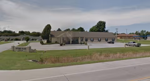 Single-story Autumn Home Care Facilities building with front entrance, parking lot, and green lawn.