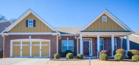 Front exterior of a residential senior living facility with a two-car garage.