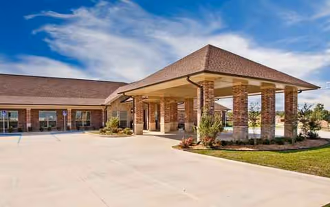 Exterior view of Montevista Rehabilitation and Skilled Care entrance with brick pillars and clear sky.