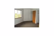 Empty carpeted room with a window and an open closet.