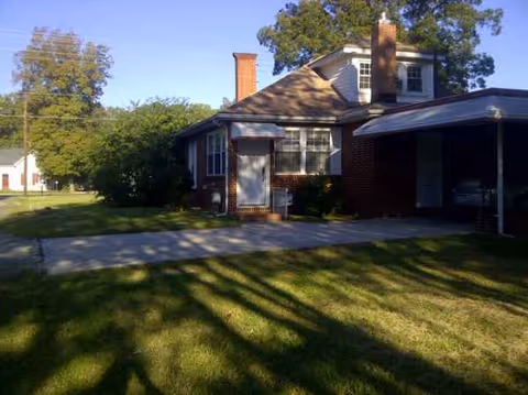 Single-story brick facility exterior with a covered entrance, driveway, and lawn.